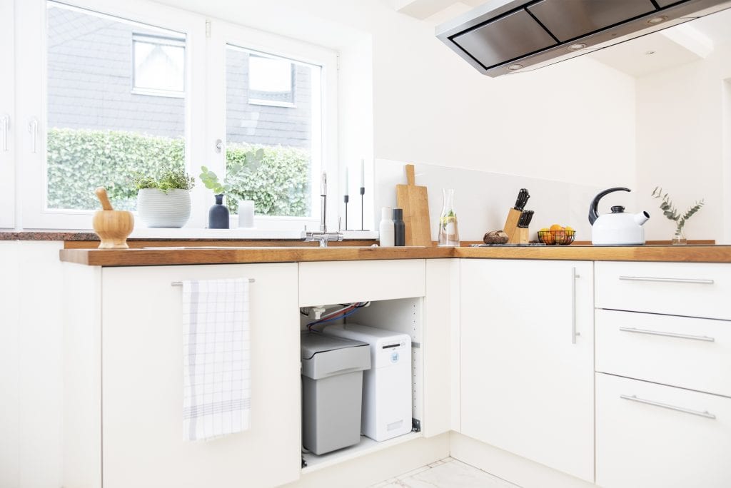 Wasserspender für zuhause in weißer Küche mit Arbeitsplatte aus Holz