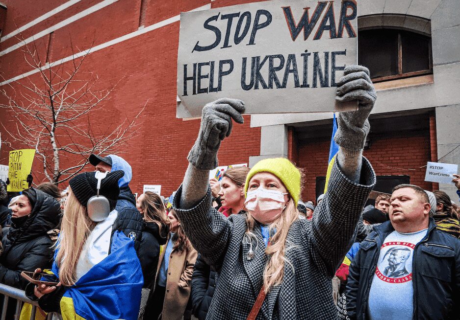 Frau demonstriert mit Schild gegen Krieg, Stoppt den Krieg helpt der Ukraine