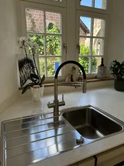 LivingTap-Armatur an der Spüle vor dem Küchenfenster