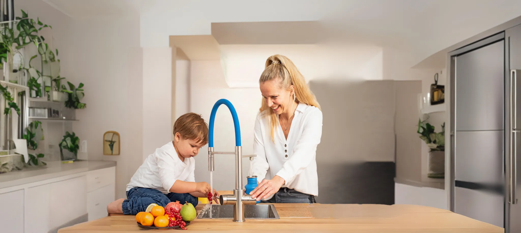 Frau und Kind nutzen einen LivingTap an einer Kücheninsel.