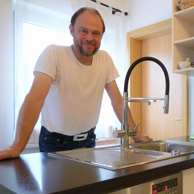 Living Water Kunde mit Glas Wasser in der Küche