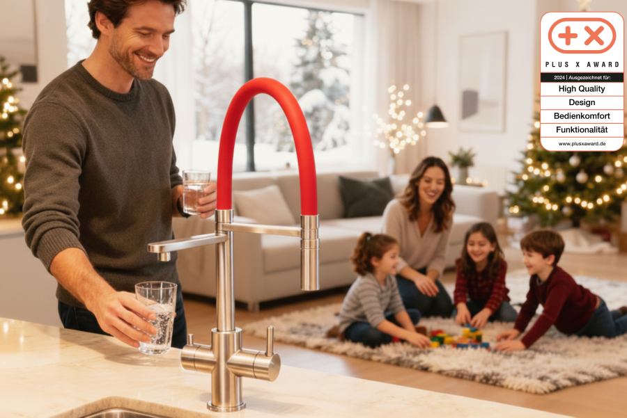 LivingTap Pro Brausearmatur in Rot in moderner Küche, Mann füllt ein Glas Wasser, Familie spielt im Wohnzimmer neben Weihnachtsbaum.