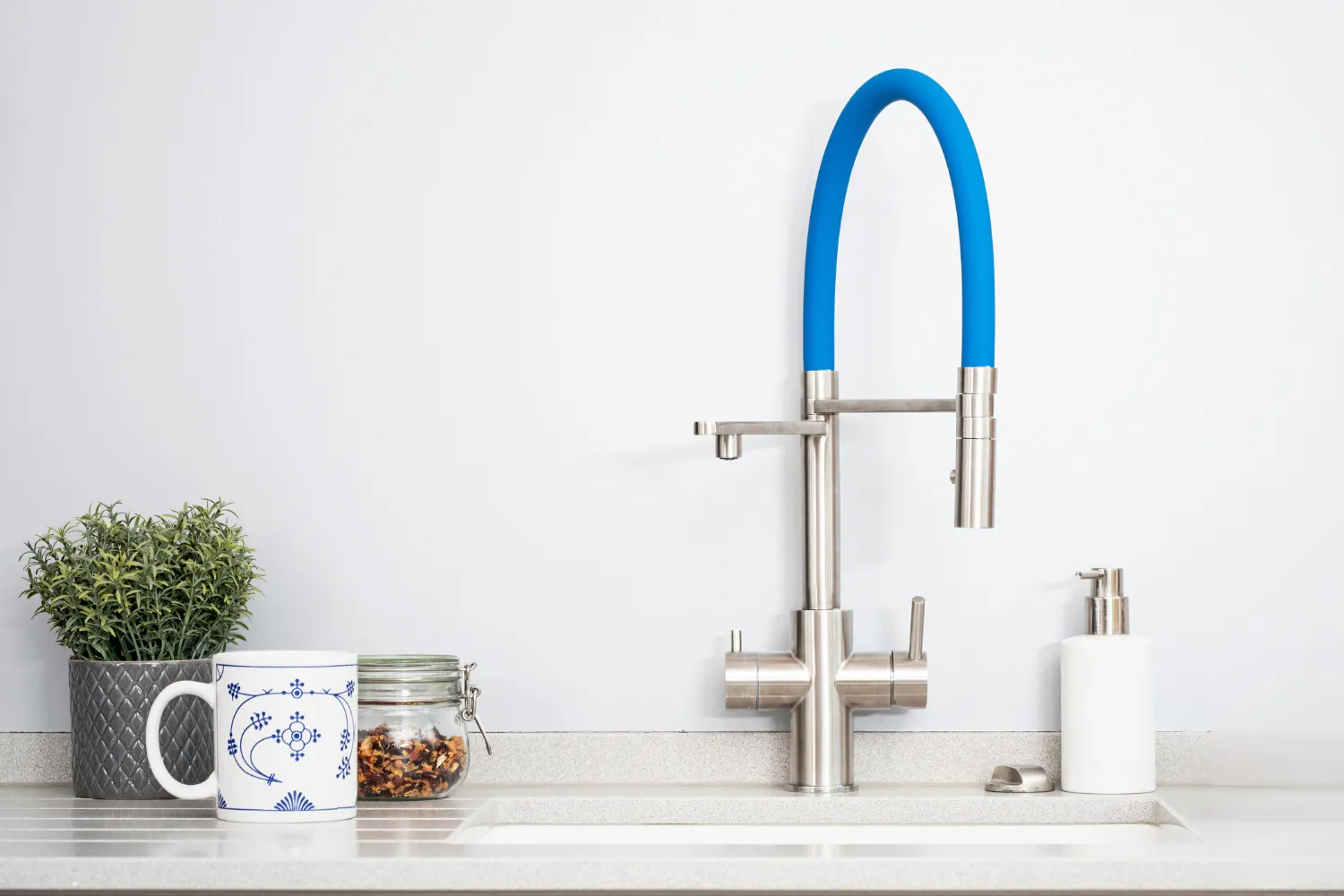 LivingTap-Armatur mit blauem Schlauch an einer Küchenspüle.