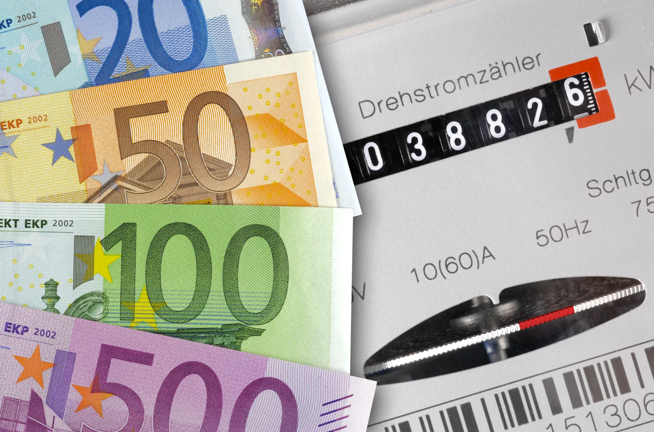 Bündel von Euro-Scheinen (20, 50, 100, 500) und ein Stromzähler.